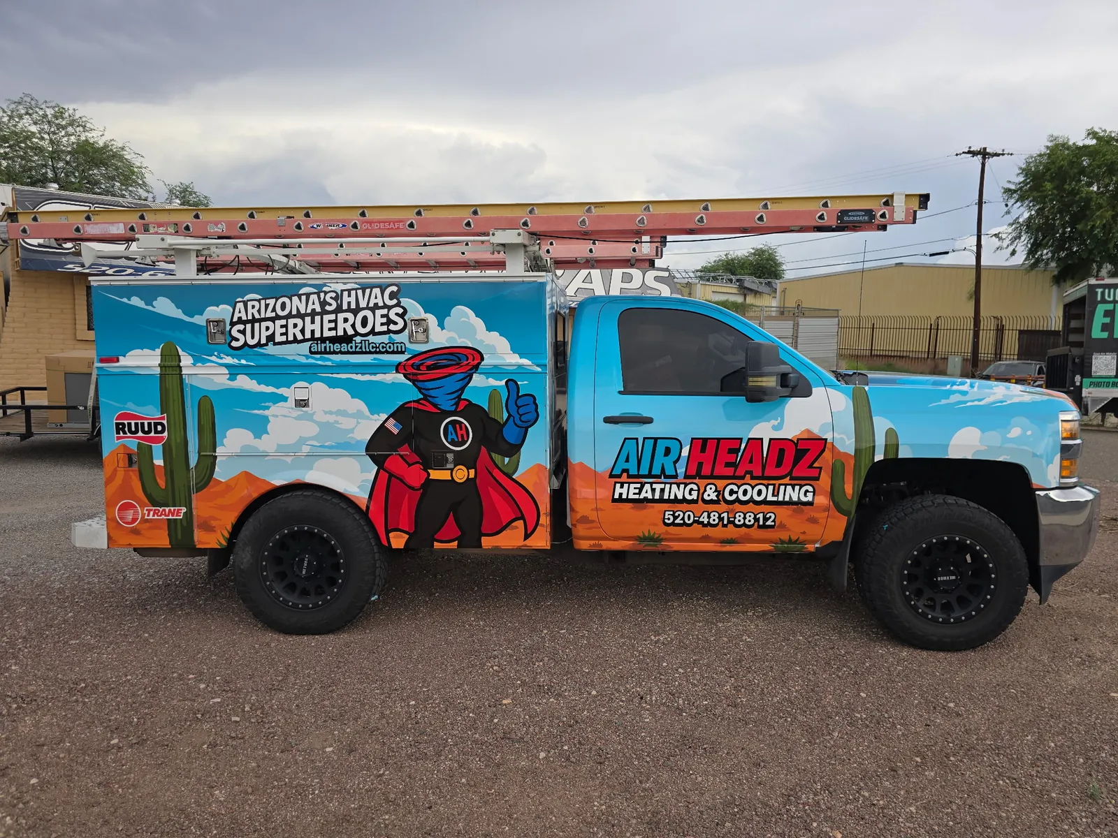 AirHeadz Chevy service truck with the superhero wrap under a Tucson monsoon sky